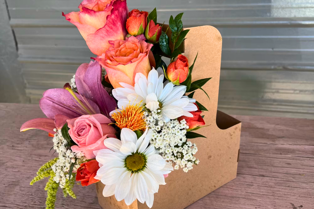Handmade floral arrangement with roses, daisies, and lilies in a gift box at Peel Museum & Botanical Garden