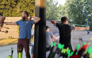 two men drawing bow and arrows in different directions at The Quiver Archery Range