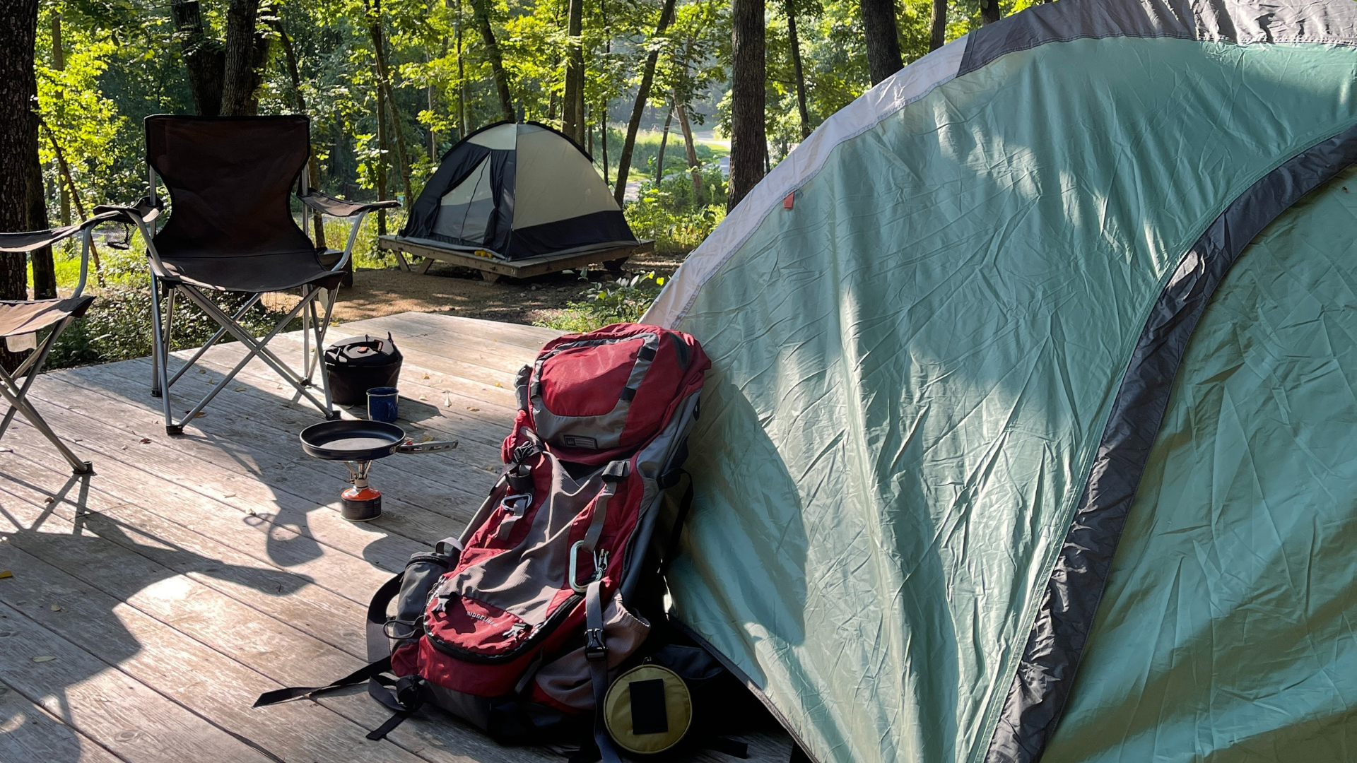 campsite with tent, backpack, and cooking gear