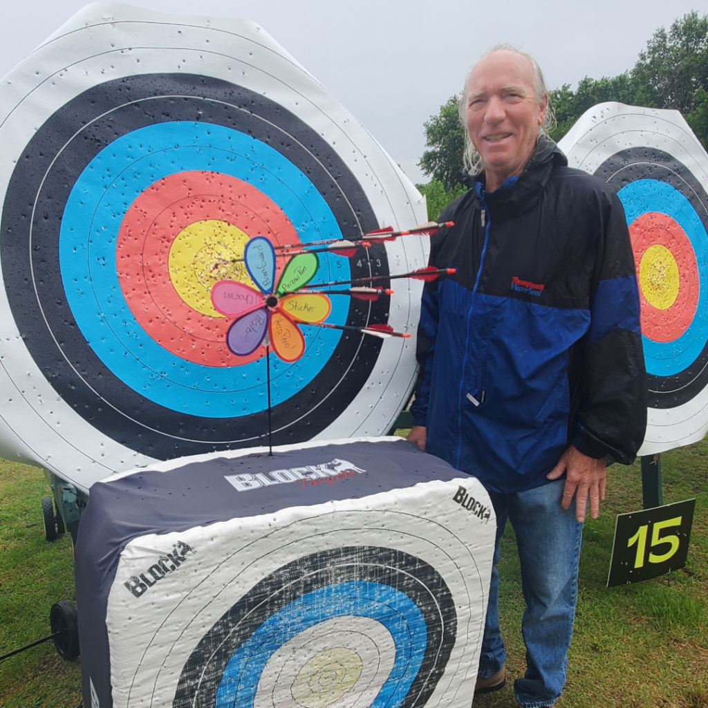 Member posing with his arrow grouping on a target at The Quiver